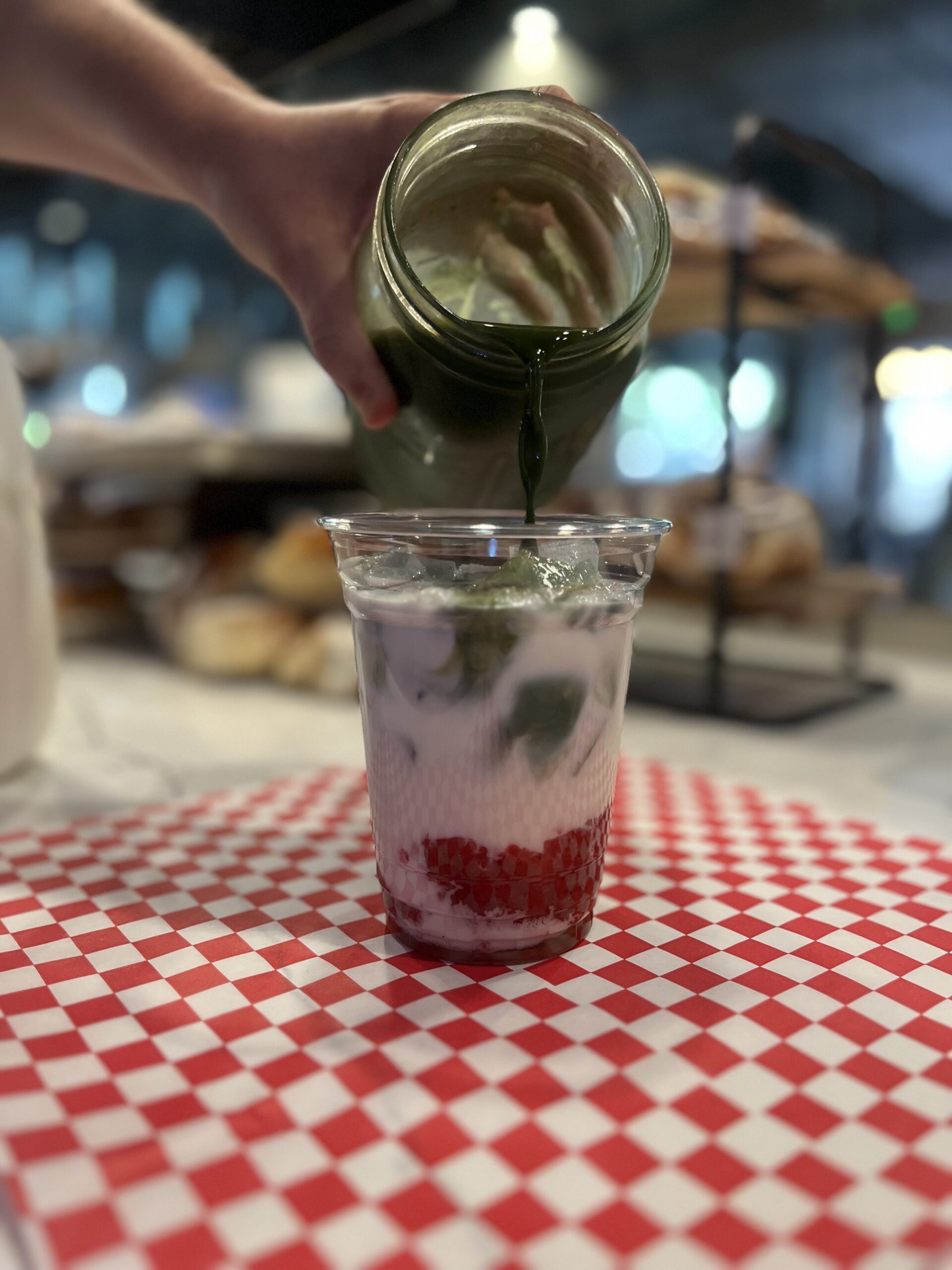 homemade matcha poured into strawberry puree and cream